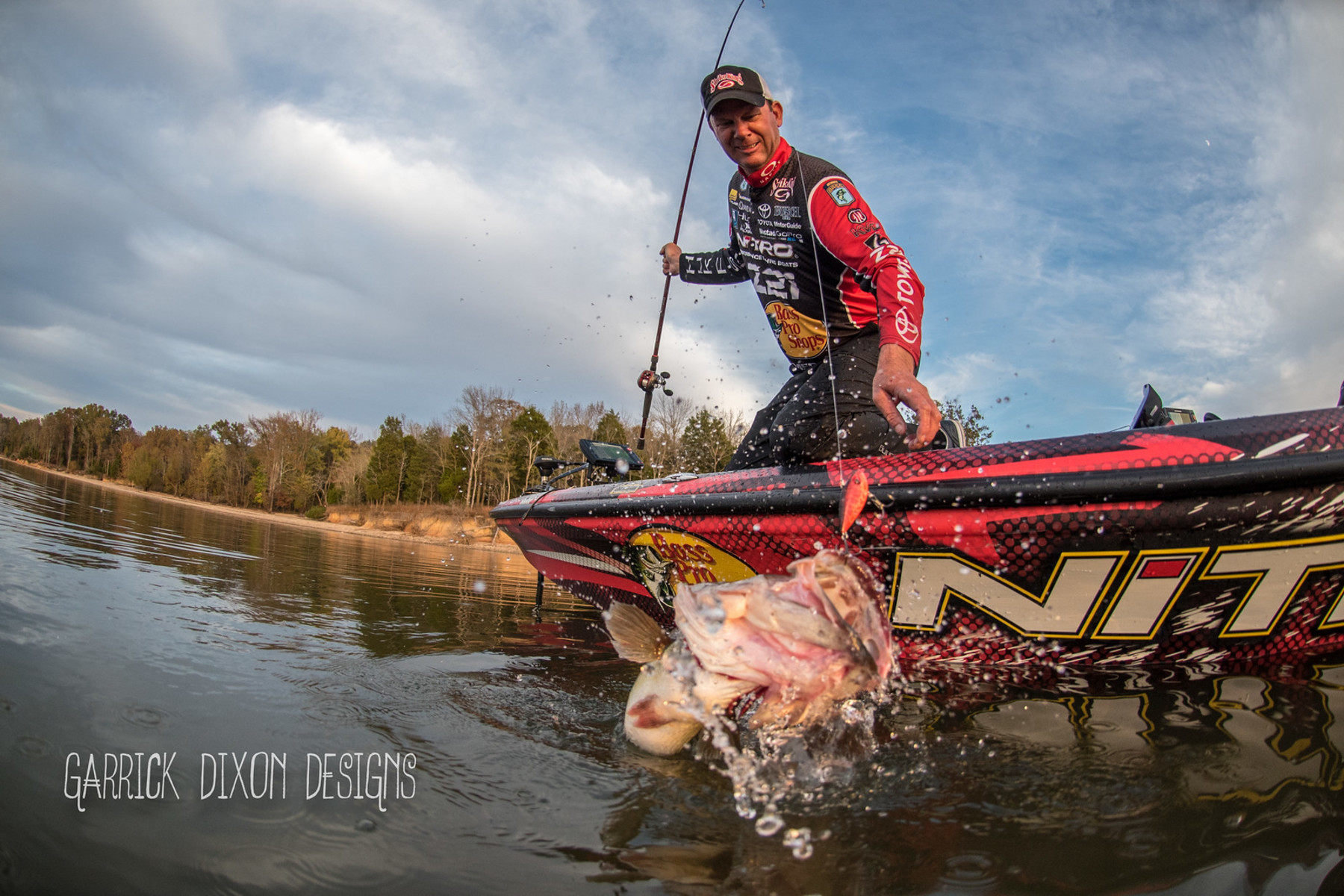 Wide action shot of Kevin VanDam about to pull a lively catch out of the water.
