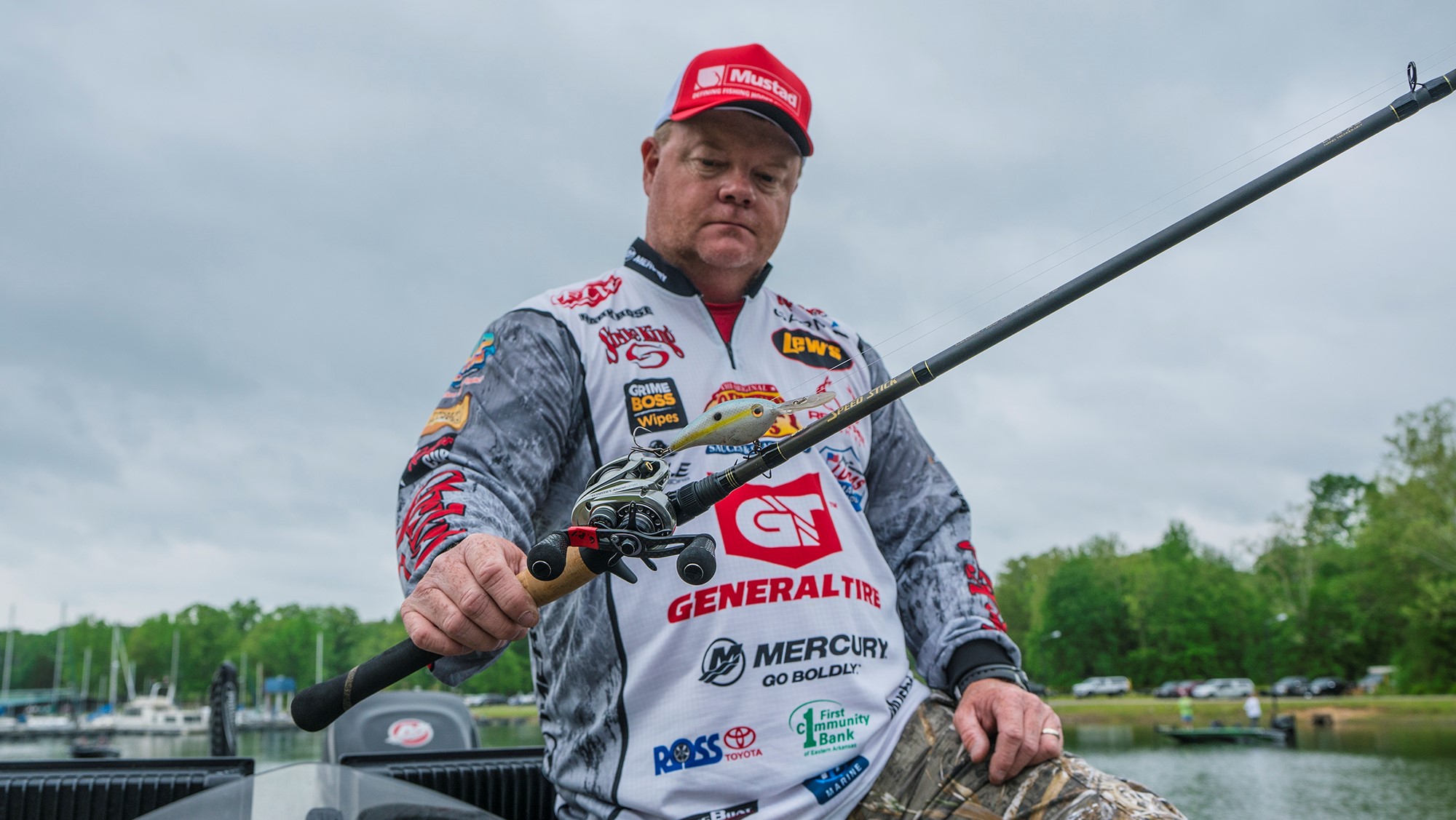 Portrait photo of American pro staffer Mark Rose holding up a rod with a balsa bait.