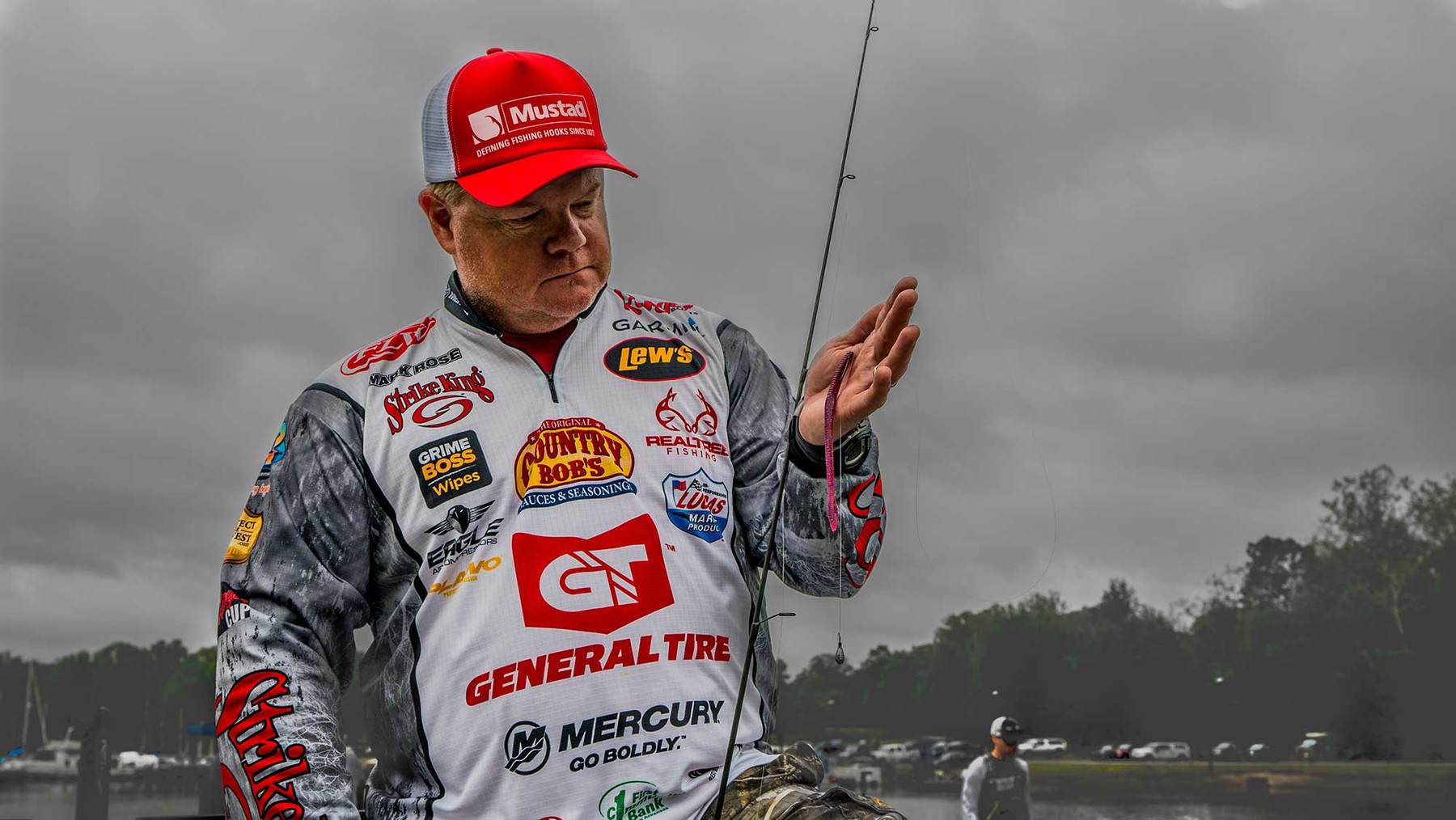 Portrait photo of American pro staffer Mark Rose holding up a rod rigged with a soft plastic bait.